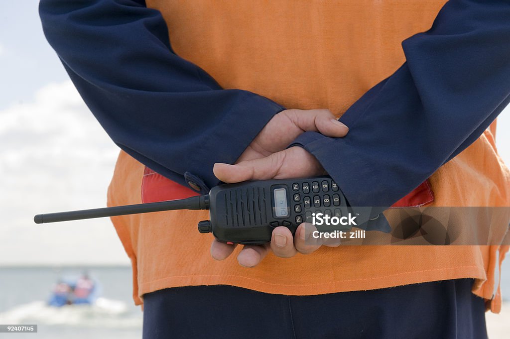 A coast guard on duty holding a walkie-talkie Monitoring of a coastal line Walkie-talkie Stock Photo