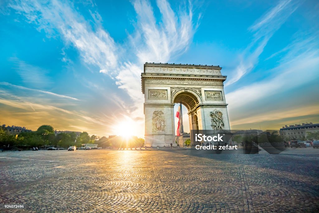 Paris Arc de Triomphe (Triumphal Arch) in Chaps Elysees at sunset, Paris, France. Architecture and landmarks of Paris. Postcard of Paris Arc de Triomphe - Paris Stock Photo