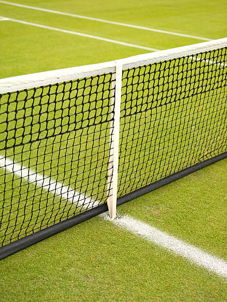 Female tennis player in sportswear hitting ball with racquet on clay court during match.