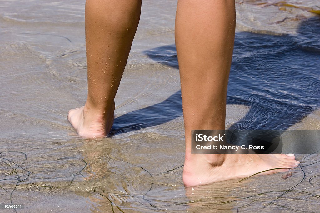 Camminare nell'acqua in spiaggia a piedi nudi, acqua, sabbia, estate, gambe - Foto stock royalty-free di Abbronzatura