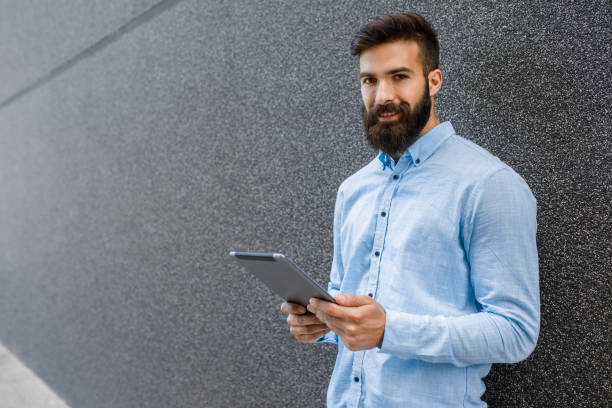 istock Stylish businessman using digital tablet outdoors 924088246