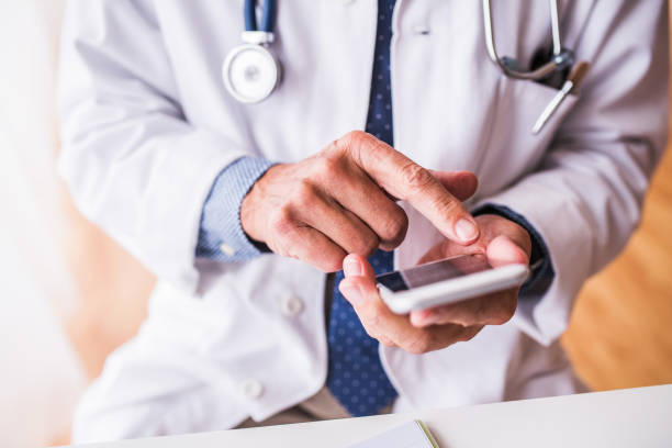 istock Senior doctor with smartphone working at the office. 924090614