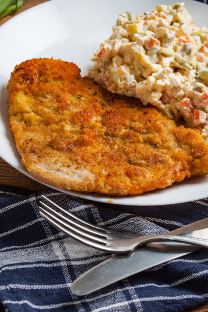 istock Fried pork chop in breadcrumbs, served with vegetable salad. 924094842