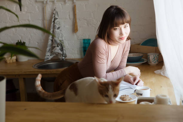 istock Girl relaxed reading a book and drinking coffee in kitchen 924097620
