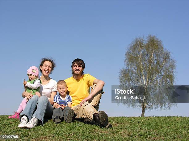 Seduta Famiglia Con Due Bambini In Primavera - Fotografie stock e altre immagini di Accudire - Accudire, Ambientazione esterna, Bambini maschi