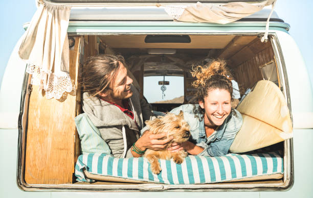 Hipster couple with cute dog traveling together on vintage mini van transport - Life inspiration concept with hippie people on minivan adventure trip in relax moment - Bright warm retro filter Hipster couple with cute dog traveling together on vintage mini van transport - Life inspiration concept with hippie people on minivan adventure trip in relax moment - Bright warm retro filter travel destinations 20s adult adventure stock pictures, royalty-free photos & images