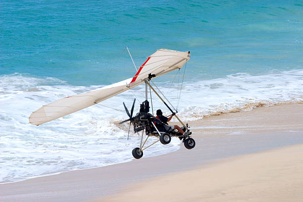 avión ultraligero flying que vienen por un descanso en la playa - avión ultraligero fotografías e imágenes de stock