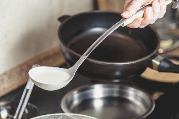 istock liquid dough is poured onto frying pan 924107684