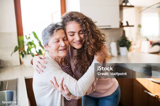 Ein Junges Mädchen Mit Großmutter Zu Hause Umarmt Stockfoto und mehr Bilder von Großmutter - Großmutter, Großeltern, Alter Erwachsener