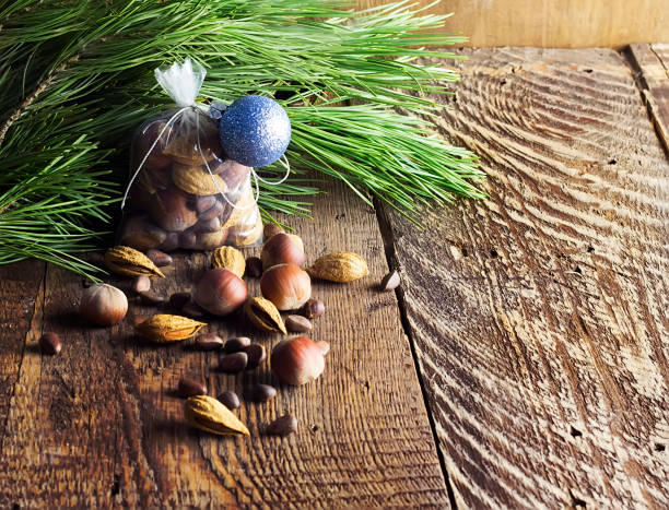 saco de navidad con frutos secos sobre un fondo de madera y ramas de un pino, una avellana, almendras, un cedro - pine nut tree pine tree pine cone fotografías e imágenes de stock