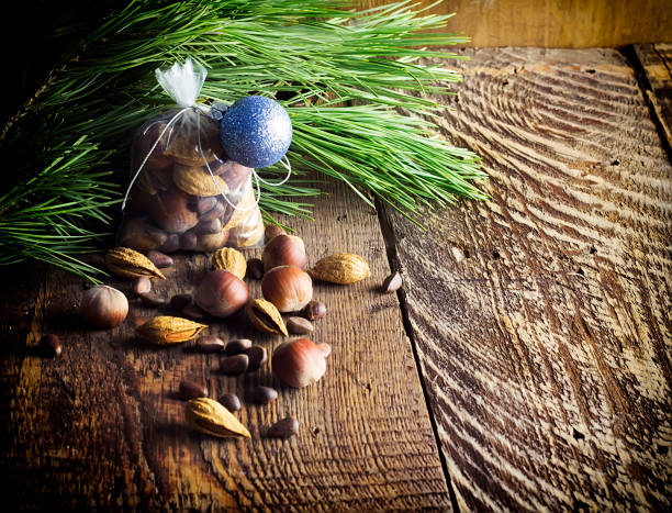 saco de navidad con frutos secos sobre un fondo de madera y ramas de un pino, una avellana, almendras, un cedro - pine nut tree pine tree pine cone fotografías e imágenes de stock
