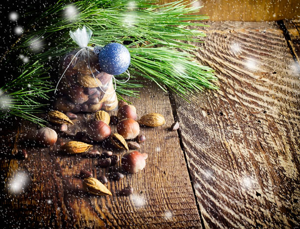 saco de navidad con frutos secos sobre un fondo de madera y ramas de un pino, una avellana, almendras, un cedro - pine nut tree pine tree pine cone fotografías e imágenes de stock