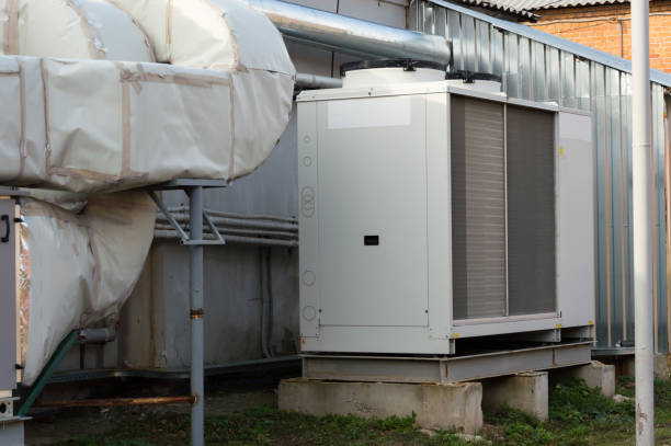 istock Gray commercial cooling unit for central ventilation system with big ventilation unit standing outdoor on the ground covered by fallen leaves 924118166