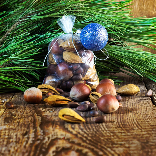świąteczny worek z orzechami na drewnianym tle i gałęzie sosny, migdały, filbert, cedr - pine nut tree pine tree pine cone zdjęcia i obrazy z banku zdjęć