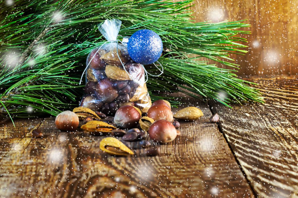 saco de navidad con frutos secos sobre un fondo de madera y ramas de un pino, una avellana, almendras, un cedro - pine nut tree pine tree pine cone fotografías e imágenes de stock