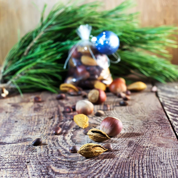 saco de navidad con frutos secos sobre un fondo de madera y ramas de un pino, una avellana, almendras, un cedro - pine nut tree pine tree pine cone fotografías e imágenes de stock