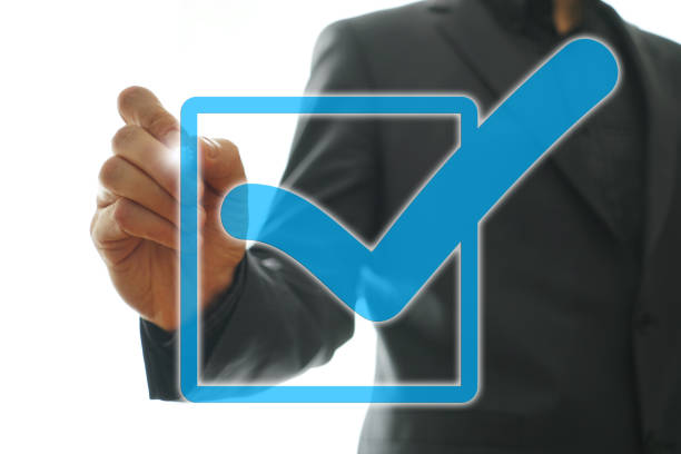 Businessman checking mark on checklist with marker