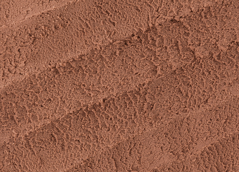 Close-up of chocolate ice cream texture with scoop marks