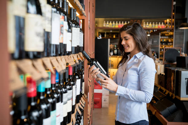 istock Young female client at a wine store choosing a wine bottle looking happy 924149464