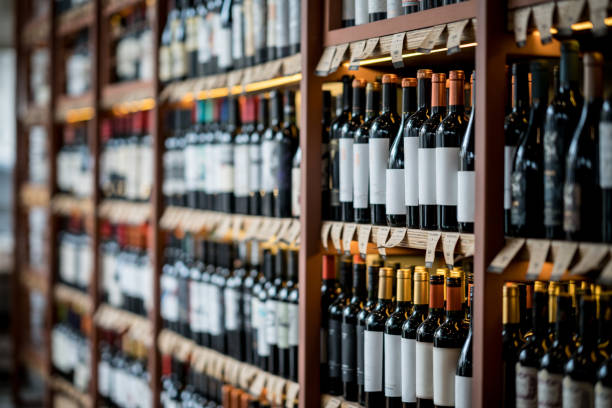 Close up of wine bottles on a shelf at a winery Close up of wine bottles on a shelf at a winery alcohol shop stock pictures, royalty-free photos & images