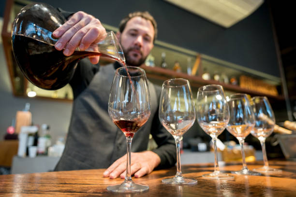 focada concurso servindo vinho de uma garrafa de vinho em um restaurante da barra - wine decanter elegance pouring - fotografias e filmes do acervo