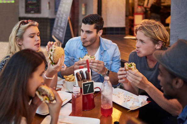 istock Young friends having burgers in restaurant 924150366