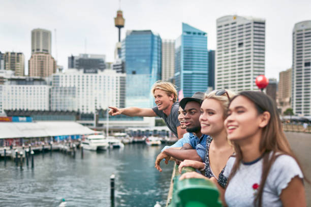 excited friends looking away against buildings - sydney australia imagens e fotografias de stock