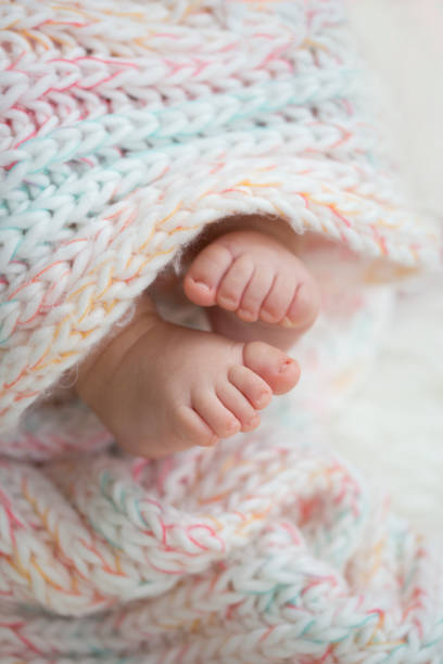 istock Baby feet on blanket showing emotions. Copy space. Selective focus 924159200
