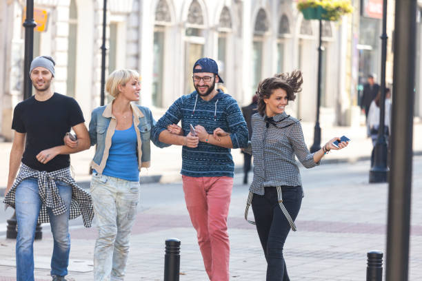 istock Friends holding hands and walking on street 924159252