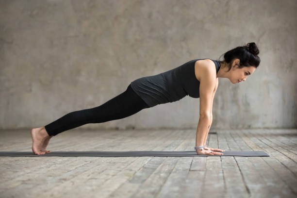 mujer joven en pose de tablón - good posture yogaclass lifestyles sport fotografías e imágenes de stock