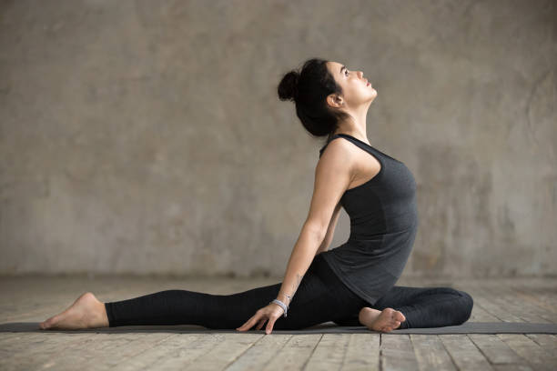 young woman doing single pigeon exercise - yin yang symbol fotos imagens e fotografias de stock