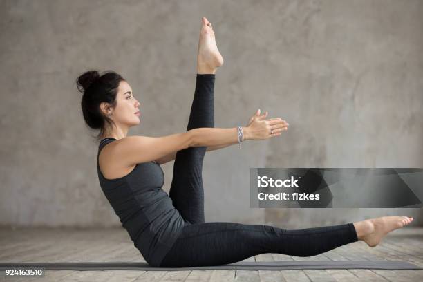 Young Woman Doing Alternate Leg Stretch Exercise Stock Photo - Download Image Now - Abdominal Muscle, Abdomen, Active Lifestyle