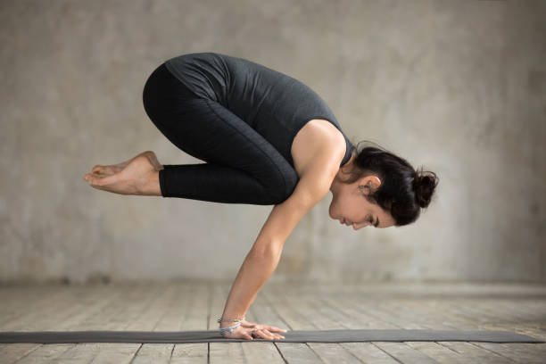 istock Young woman doing Bakasana exercise 924163532