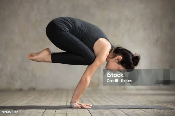 Young Woman Doing Bakasana Exercise Stock Photo - Download Image Now - Yoga, Crow Pose, Portrait