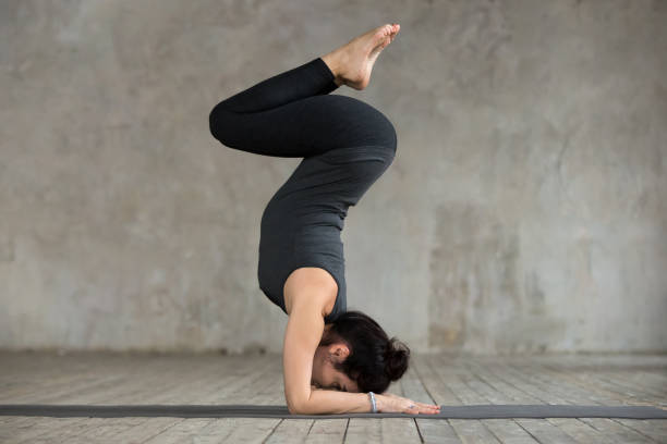 istock Young woman doing Pincha Mayurasana exercise 924163564