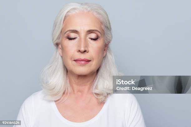 Close Up Portrait Of Confident Concentrated Mature Woman With Wrinkles On Face With Closed Eyes With Nude Make Up Isolated On Gray Background Stock Photo - Download Image Now