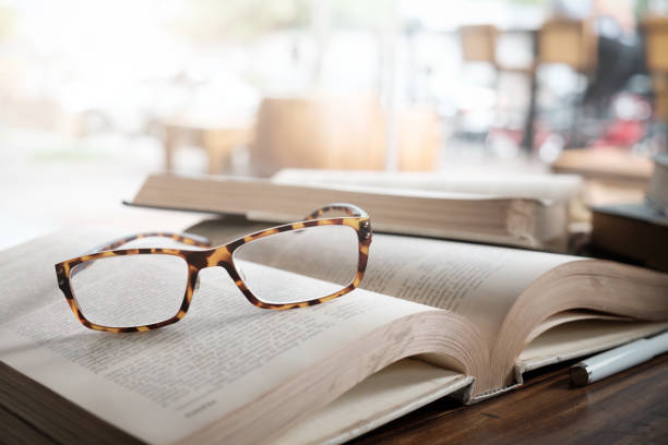 istock Glasses on opening book in library or cafe. 924170258