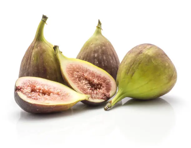 Three figs and two sliced halves rose flesh isolated on white background ripe fresh purple green"n