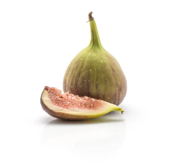 One fig and one slice isolated on white background ripe fresh purple green and rose flesh"n