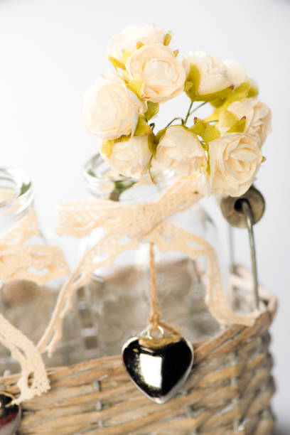 istock Decorative glass bottle with a bouquet of small artificial roses. 924179392