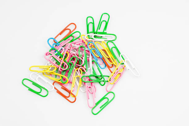 Colorful office paper clips isolated on white ground. Office accessories on a white table. White background