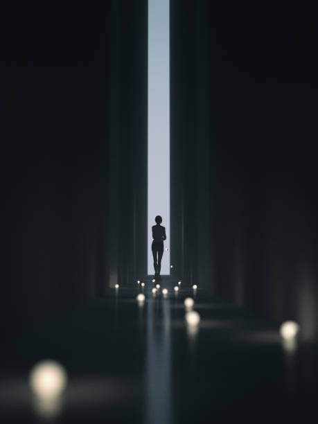 Exit Young woman in a dark, narrow corridor, walking towards the unknown. She is holding a bunch of lit lightbulbs in her arms falling behind stock pictures, royalty-free photos & images