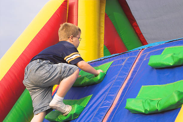 menino brincando na pista de obstáculos - inflatable child carnival obstacle course imagens e fotografias de stock