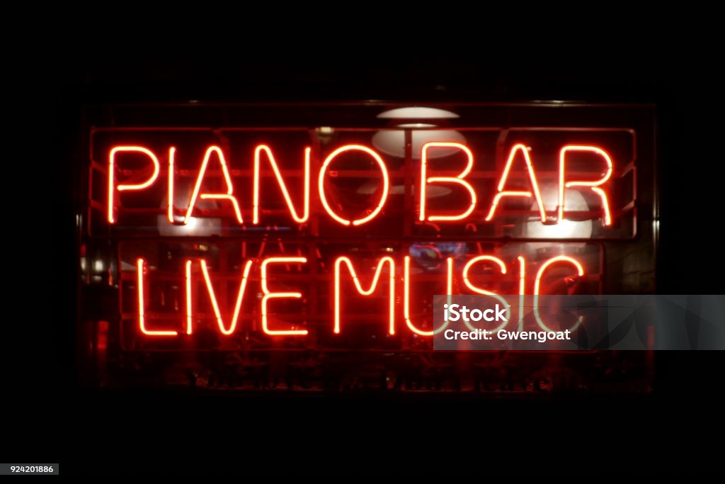 Neon light : Piano Bar, Live Music Close-up on a neon light shaped into the short phrase "Piano Bar, Live Music". Neon Lighting Stock Photo
