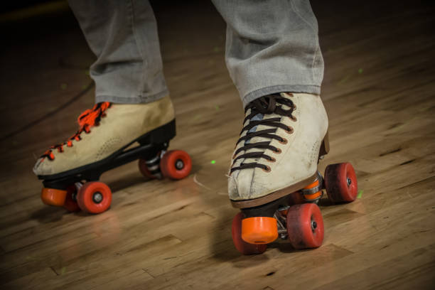 Close up of Roller Skates A close up of a man’s feet wearing skates standing on a roller rink. roller rink stock pictures, royalty-free photos & images