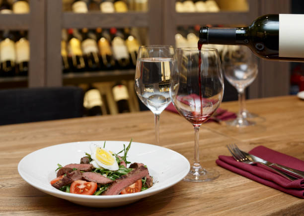 Pouring red wine in a glass, gourmet restaurant