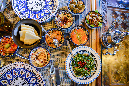 Middle eastern or arabic dishes and assorted meze, concrete rustic background. Meat kebab, falafel, baba ghanoush, muhammara, hummus, sambusak, rice, tahini, kibbeh, pita Halal food Lebanese cuisine