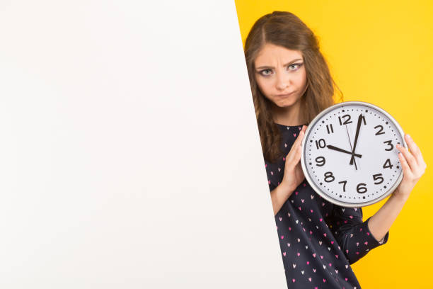 istock Brunette woman with clocks and blank banner 924256608