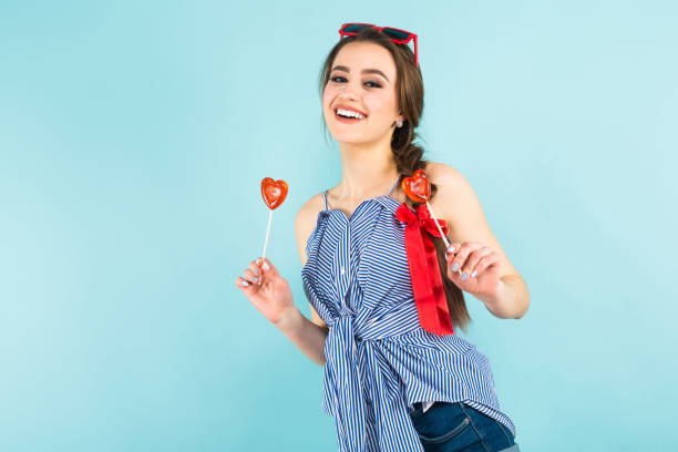 istock Young woman with heart-shaped lollipops 924256900