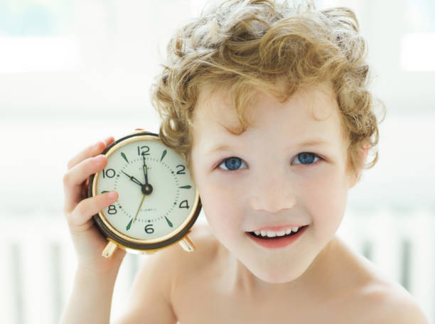 istock Happy little boy listen an antique clock. 924257888